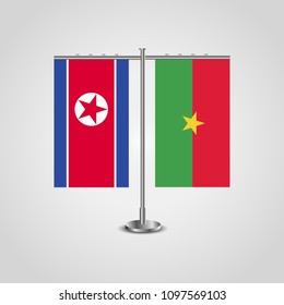 Table stand with flags of North Korea and Burkina Faso.Two flag. Flag pole. Symbolizing the cooperation between the two countries. Table flags
