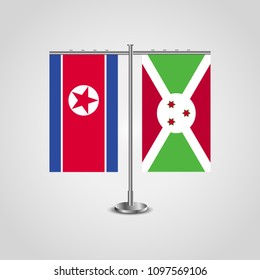 Table stand with flags of North Korea and Burundi.Two flag. Flag pole. Symbolizing the cooperation between the two countries. Table flags