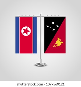 Table stand with flags of North Korea and Papua New Guinea.Two flag. Flag pole. Symbolizing the cooperation between the two countries. Table flags