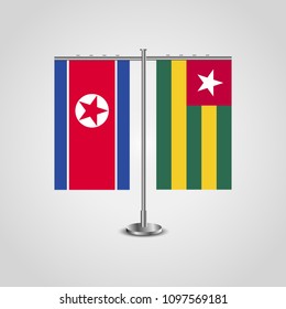 Table stand with flags of North Korea and Togo.Two flag. Flag pole. Symbolizing the cooperation between the two countries. Table flags