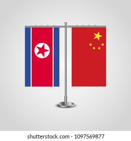 Table stand with flags of North Korea and China.Two flag. Flag pole. Symbolizing the cooperation between the two countries. Table flags
