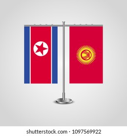 Table stand with flags of North Korea and Kyrgyzstan.Two flag. Flag pole. Symbolizing the cooperation between the two countries. Table flags