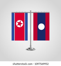 Table stand with flags of North Korea and Laos.Two flag. Flag pole. Symbolizing the cooperation between the two countries. Table flags