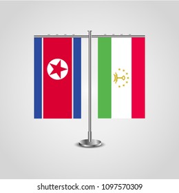 Table stand with flags of North Korea and Tajikistan.Two flag. Flag pole. Symbolizing the cooperation between the two countries. Table flags
