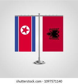 Table stand with flags of North Korea and Albania.Two flag. Flag pole. Symbolizing the cooperation between the two countries. Table flags