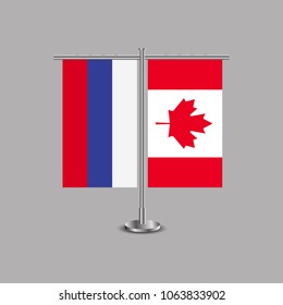 Table stand with flags of Russia and Canada.Two flag. Flag pole. Symbolizing the cooperation between the two countries.Table flags