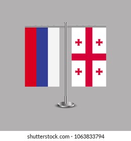 Table stand with flags of Russia and Georgia.Two flag. Flag pole. Symbolizing the cooperation between the two countries.Table flags