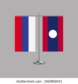 Table stand with flags of Russia and Laos.Two flag. Flag pole. Symbolizing the cooperation between the two countries.Table flags