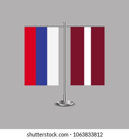 Table stand with flags of Russia and Latvia.Two flag. Flag pole. Symbolizing the cooperation between the two countries.Table flags