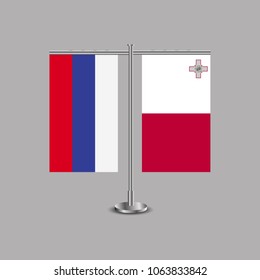 Table stand with flags of Russia and Malta.Two flag. Flag pole. Symbolizing the cooperation between the two countries.Table flags