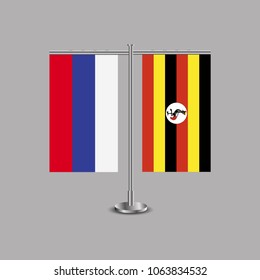 Table stand with flags of Russia and Uganda.Two flag. Flag pole. Symbolizing the cooperation between the two countries.Table flags