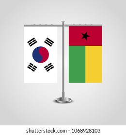 Table stand with flags of South Korea and Guinea-Bissau.Two flag. Flag pole. Symbolizing the cooperation between the two countries. Table flags