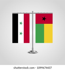 Table stand with flags of Syria and Guinea-Bissau.Two flag. Flag pole. Symbolizing the cooperation between the two countries. Table flags