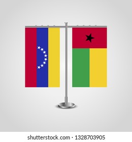 Table stand with flags of Venezuela and Guinea-Bissau. Two flag. Flag pole. Symbolizing the cooperation between the two countries. Table flags

