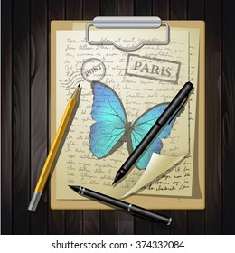 table top with sketching paper and butterfly