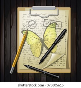 table top with sketching paper and butterfly