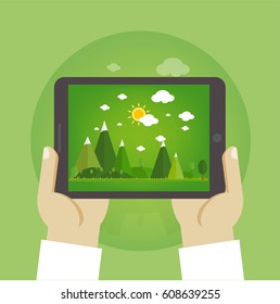 tablet computer in hand on the forest backgrounds.