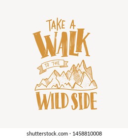 Take A Walk To The Wild Side motivational slogan or text handwritten with calligraphic font and decorated by mountains. Trendy lettering isolated on light background. Monochrome vector illustration.