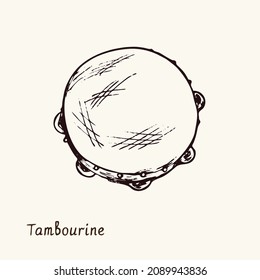 Tambourine. Ink black and white doodle drawing in woodcut style with inscription.