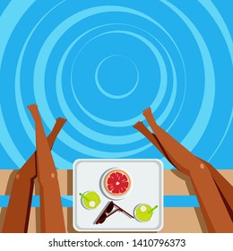tanned legs of women sitting on a bench and a tray with fruit and cocktails on the background of sea water