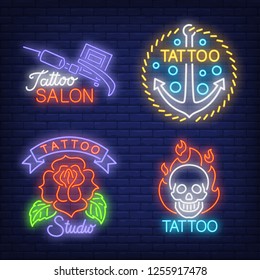 Tattoo machine, anchor, rose and skull neon signs set with text. Tattoo salon advertisement design. Night bright neon sign, colorful billboard, light banner. Vector illustration in neon style.