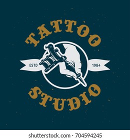 Tattoo studio emblem. Hand holding tattoo machine. Tattoo shop advertising. Vector vintage illustration.