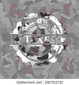Taxes written on a grey camTaxes on grey camo textureouflage texture