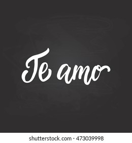 Te amo - I love you, lettering calligraphy phrase in Spanish, handwritten text isolated on the black chalkboard background. Fun typography greeting and invitation card or t-shirt print design.