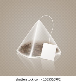 Tea bag pyramid shape isolated on transparent background. Realistic 3d triangle teabag with empty paper label. Vector mockup for tea advertising design.
