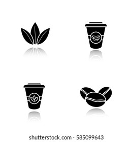 Tea and coffee drop shadow black icons set. Roasted coffee beans, tea leaves and disposable paper cups. Isolated vector illustrations