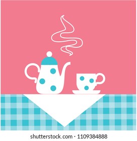 Tea or coffee pot and cup standing on the table cloth.