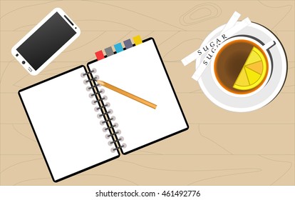 tea cup, notebook and mobile phone on a wooden table