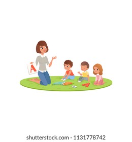 Teacher and little kids sitting on soft carpet and learning alphabet letter A. Child development center or kindergarten. Flat vector design