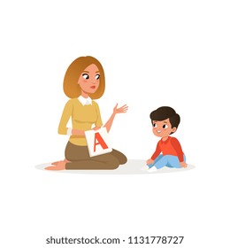 Teacher Showing Flash Card With Letter A To Her Little Pupil. Young Woman And Preschool Boy. Lesson In Kindergarten. Flat Vector Design