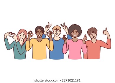 Team of diverse people of different genders and ages or nationalities pose together for group shot. Multiracial people working or studying in same team smiling and showing friendly gestures