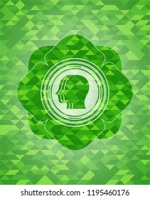 team work icon inside green emblem with triangle mosaic background