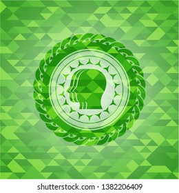 team work icon inside green emblem with triangle mosaic background