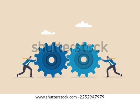 Teamwork and cooperation in a business setting, idea that working together can lead to success, collaboration or synergy concept, businessman push gear cogwheels together leading to success.