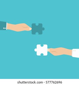 Teamwork and cooperation concept. Hands holding and putting puzzle pieces together.