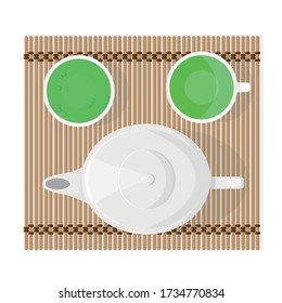 A teapot and two cups with thick green tea for a tea ceremony.