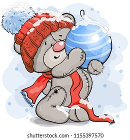 Teddy bear in a warm hat holding a huge Christmas ball toy.