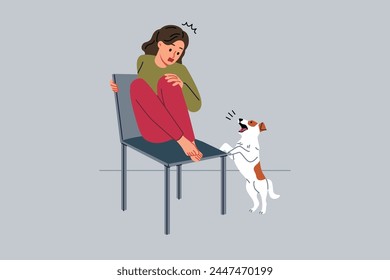 Teenage girl is afraid of dog and climbs onto chair to hide from puppy and needs treatment for cynophobia. Kid feels panic attack at sight of pets due to cynophobia or possibility of allergic reaction