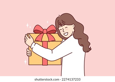 Teenage girl with big gift box with red ribbon smiling overjoyed at unexpected surprise from parents or friends. Positive child is happy to receive gift in honor of birthday or Christmas Eve 