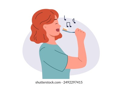 Teenage girl brushes teeth during morning wash and sings songs enjoying process of healing oral cavity. Cheerful woman brushes teeth to prevent caries and get rid of bad breath left after eating.