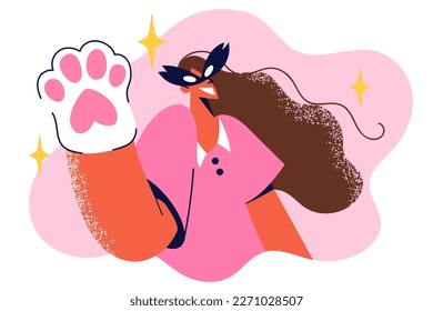 Teenage girl in cat mask waves kitten glove to say hello to participants of children party or Halloween masquerade. Schoolgirl came to party in casual clothes and cats paw on hand 