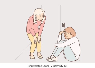 Teenage girl is crying sitting on floor in corridor near sister, who wants to console frustrated peer. Concept teenage crisis and need for psychological support for children with mental problems