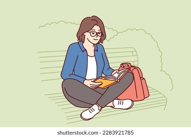 Teenage girl is reading book sitting on park bench enjoying good summer weather and intriguing plot of novel or fiction. Young woman spends leisure time outdoors doing self-education