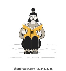 Teenage girl reading a book while sitting on the floor