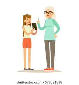 Teenage Girl Showing Tablet To Grandmother, Part Of Grandparents Having Fun With Grandchildren Series