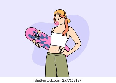 Teenage girl with skateboard in hands inflates bubble from chewing gum, demonstrating involvement in youth subculture. Gen z woman in crop top and wide-legged pants holds skateboard during summer walk